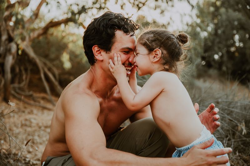 ילדה מנשקת את אבא בין העצים